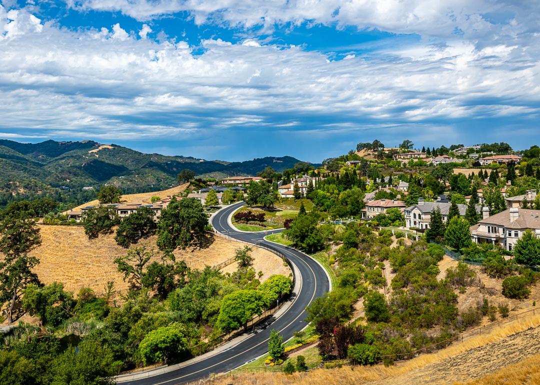 A winding road leading up to sprawling homes in the hills.