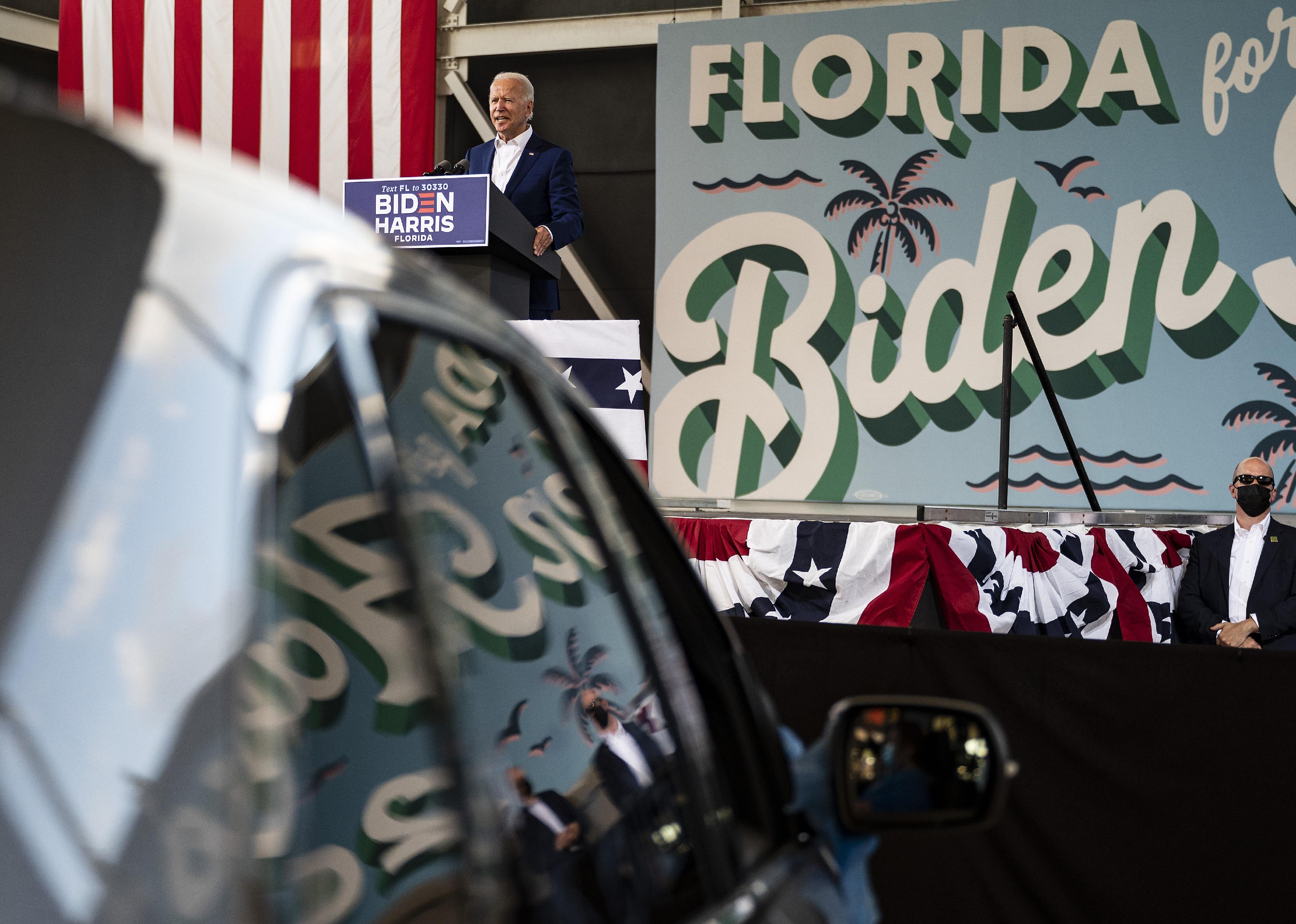 Biden speaking to a crowd in front of a Florida for Biden sign.