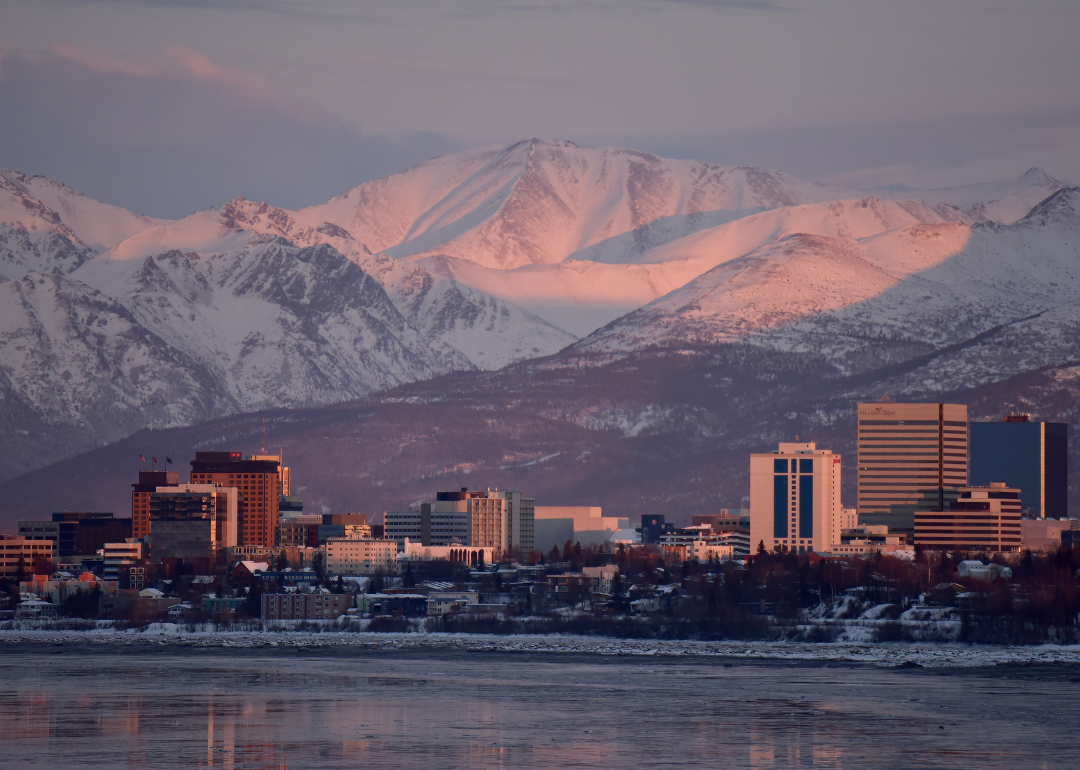 Downtown Anchorage, AK on the water with snowy mountains in the background.