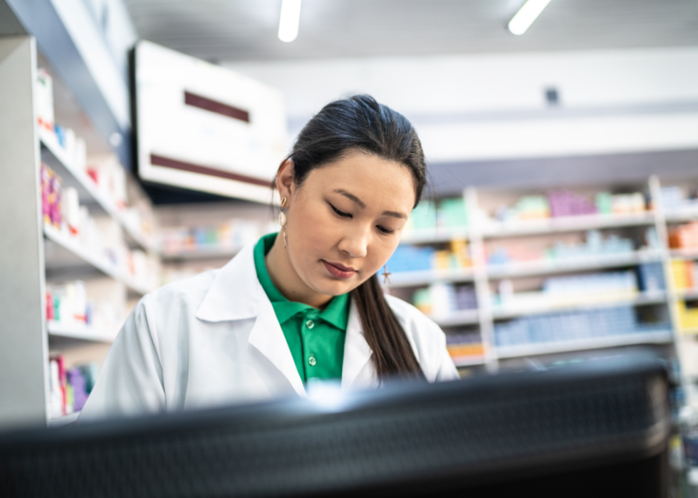 Female pharmacist behind a computer.