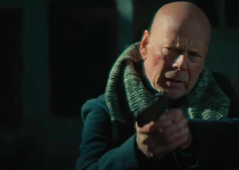 A beat-up Bruce Willis holds and points a gun.