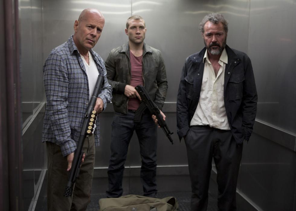 Three men with big guns wait in an elevator.