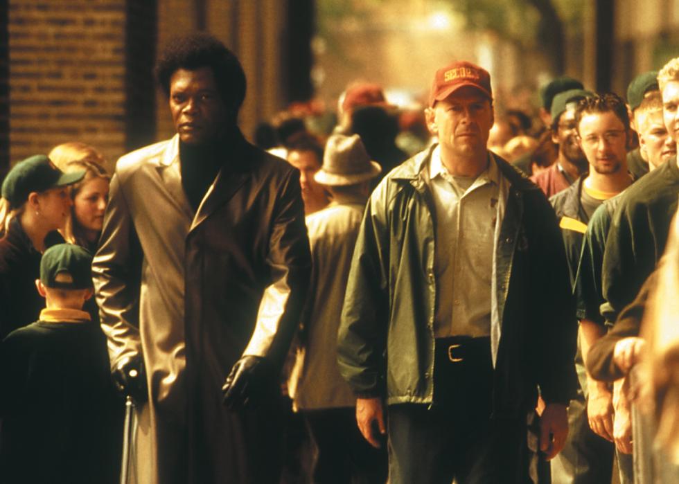 Bruce Willis and Samuel L. Jackson walk through a crowd of people.