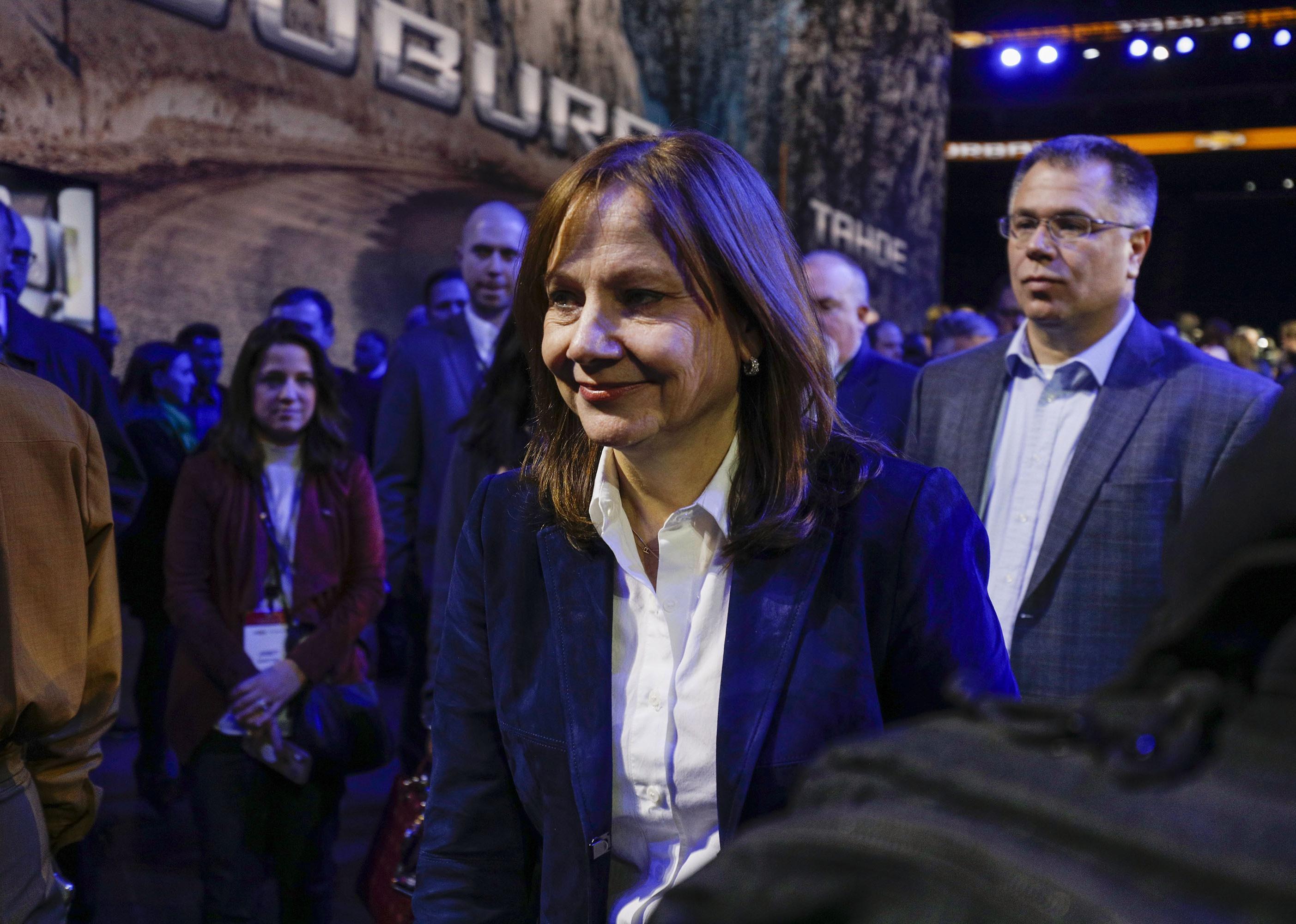 Mary Barra smiling and walking through a crowd.