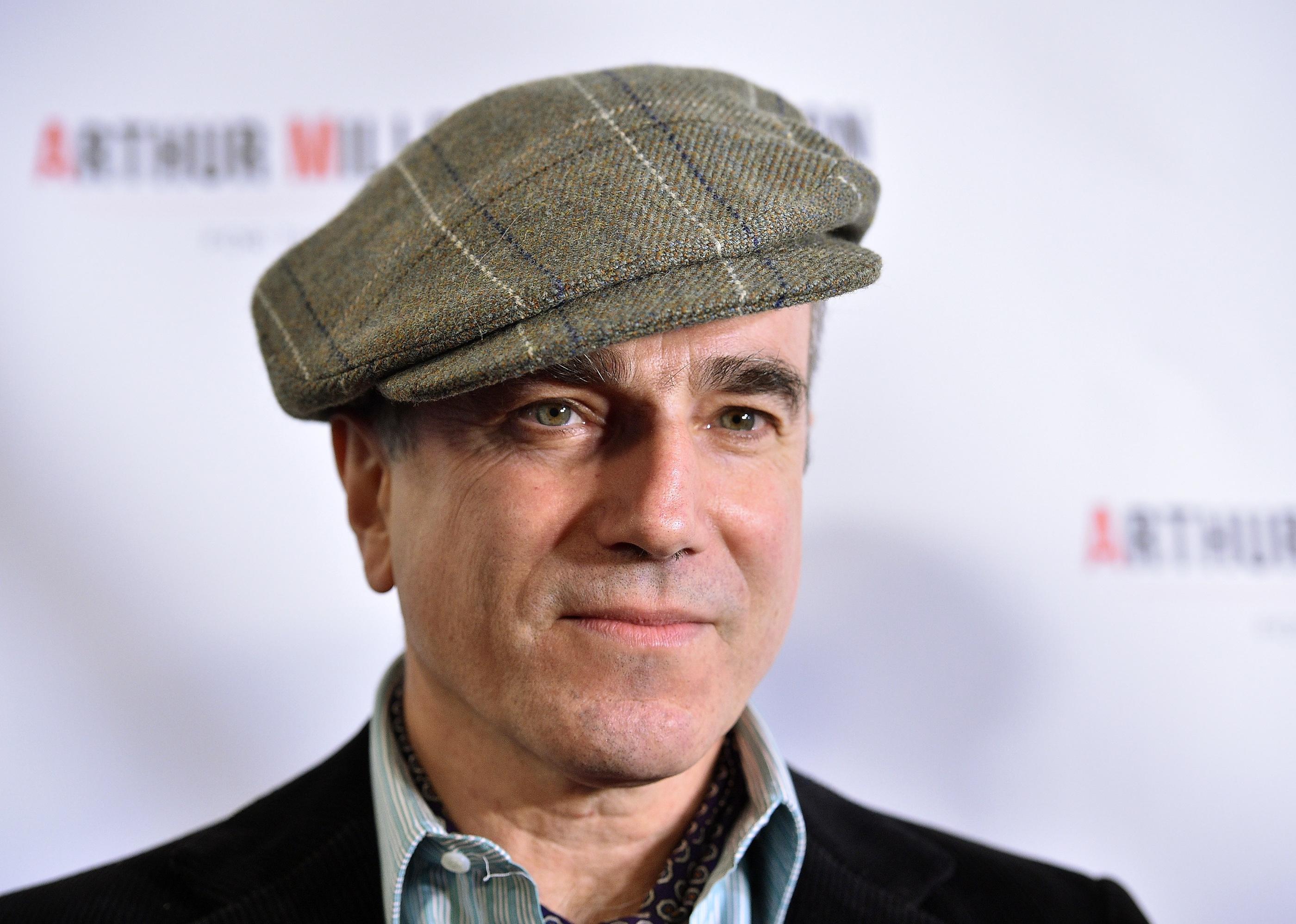 Daniel Day-Lewis in a black blazer and plaid donegal hat.