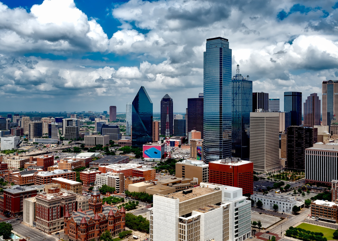 An aerial view of downtown Dallas under a blue cloudy sky.