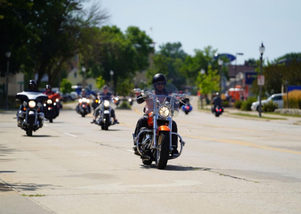 A group of motorcycles riding down a street.