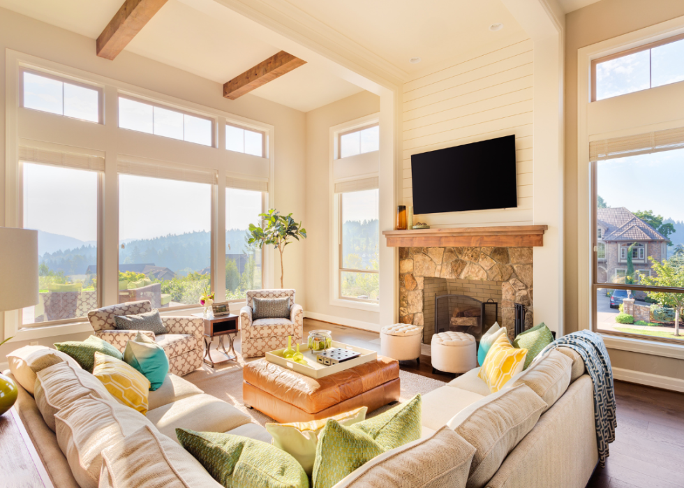 A large living room with natural light and a wooded view.