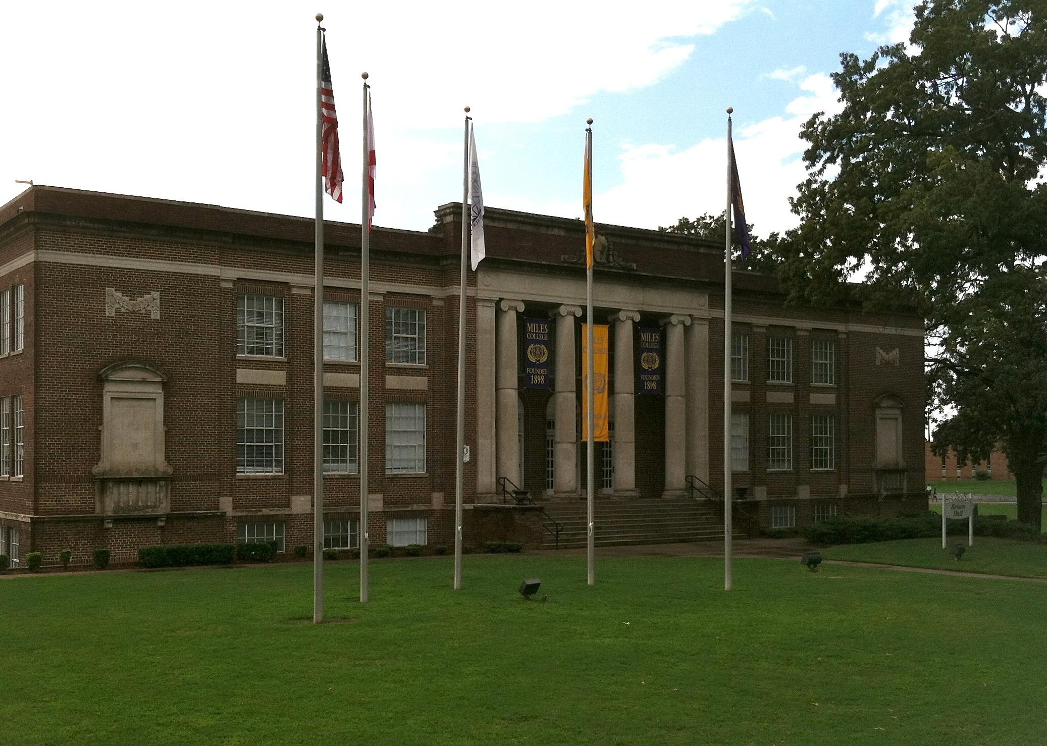 A historic red brick building with flags in front.