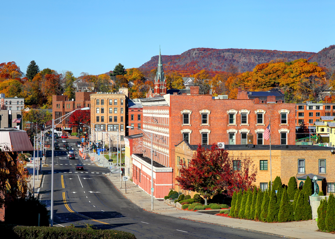 A small road lined with historic buildings and surrounded by fall foliage.