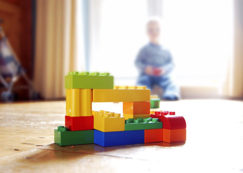 Lego building blocks with a blurred out child in the background.