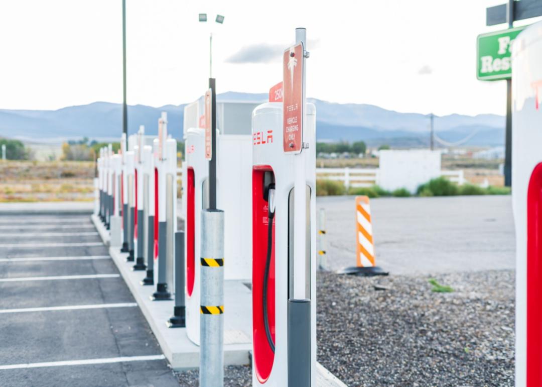 Empty Tesla charging station in Utah with mountains in the background.
