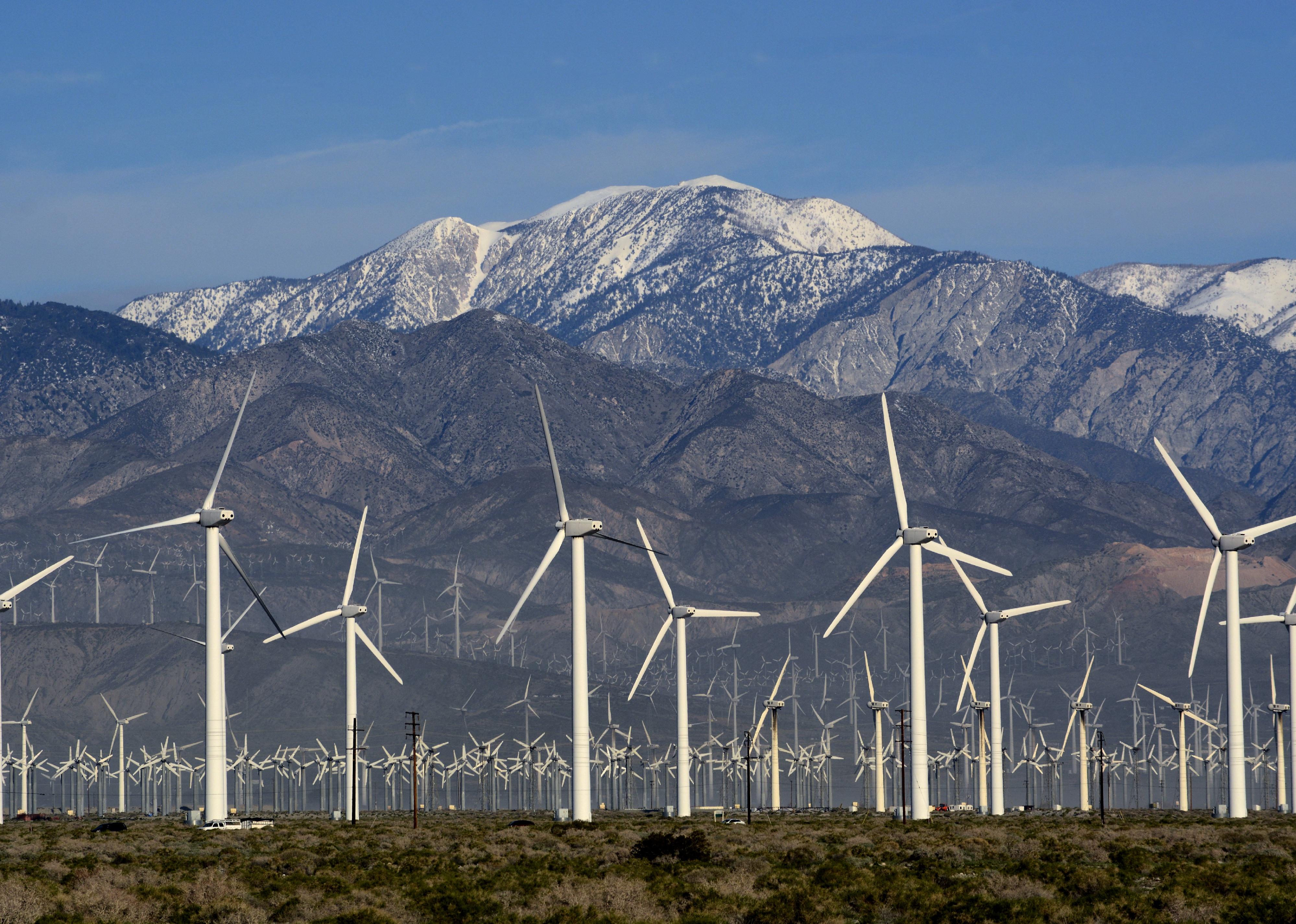 A wind farm in front of snowy mountains in Palm Springs, California.