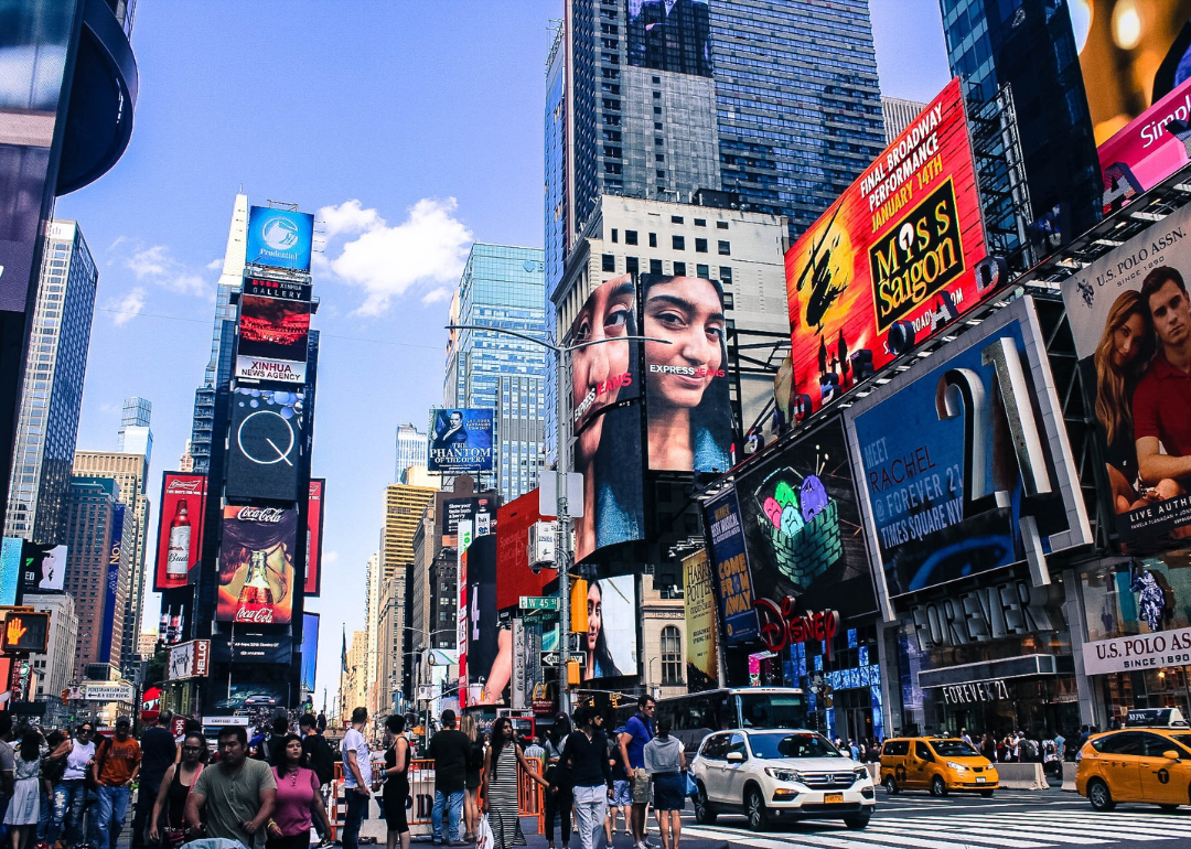 People, cars, and businesses in bustling Times Square.