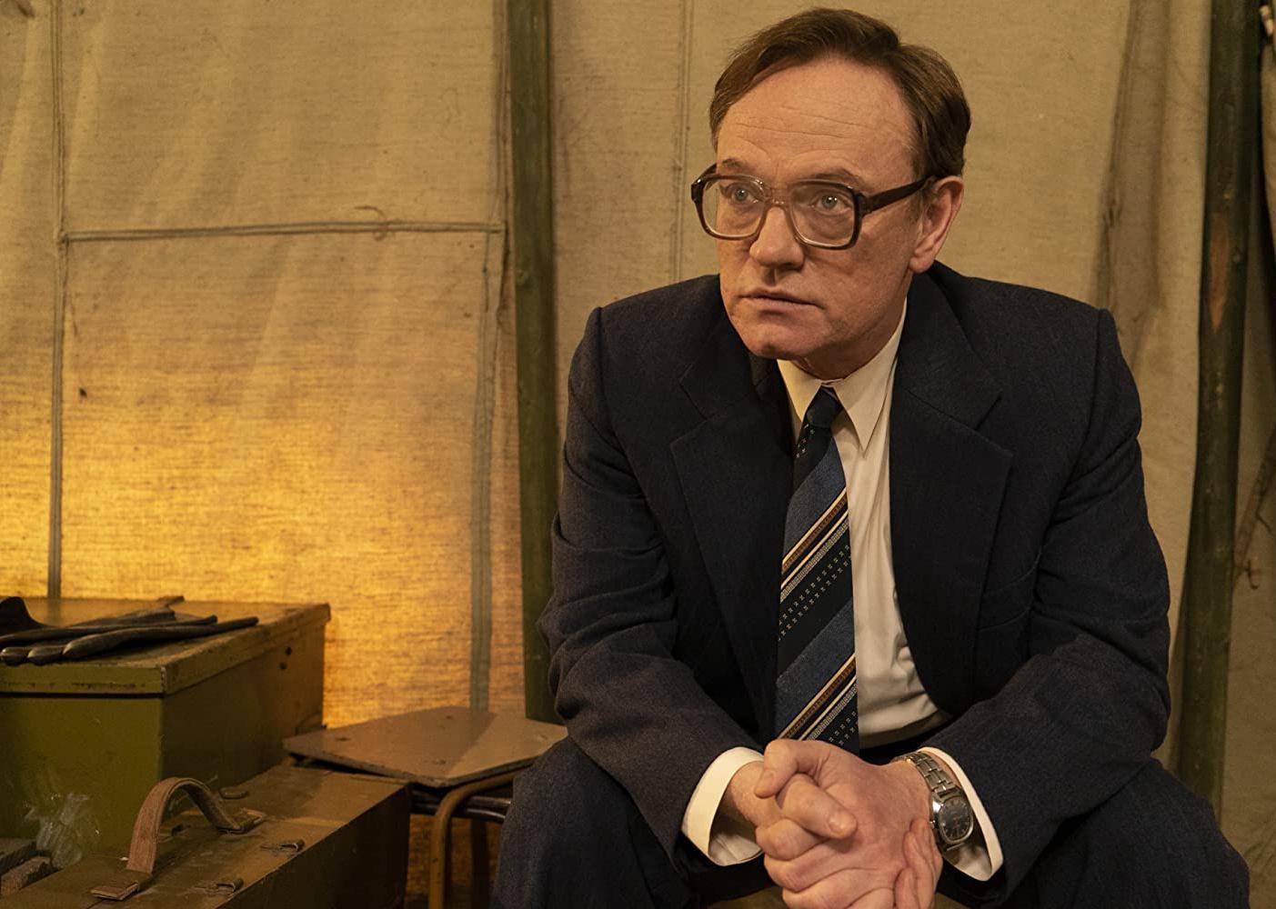 Jared Harris sitting in a chair.