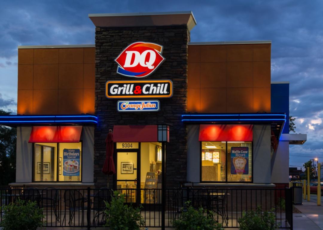 The exterior of a brick Dairy Queen restaurant at night.