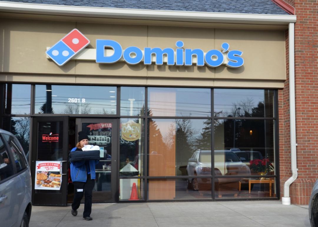 A Domino's employee carrying an order out for delivery.