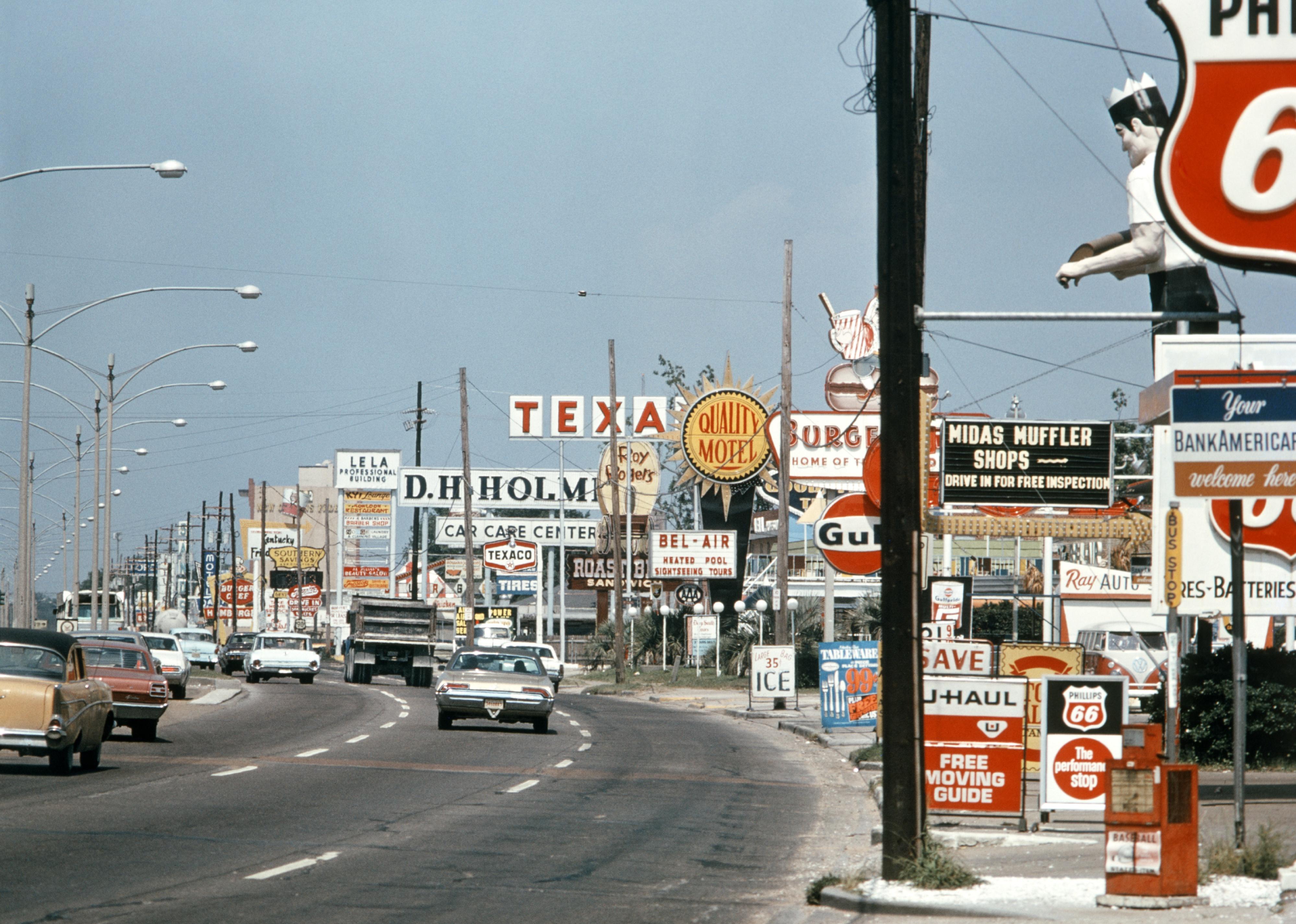 1970s street packed with store signs and cars.