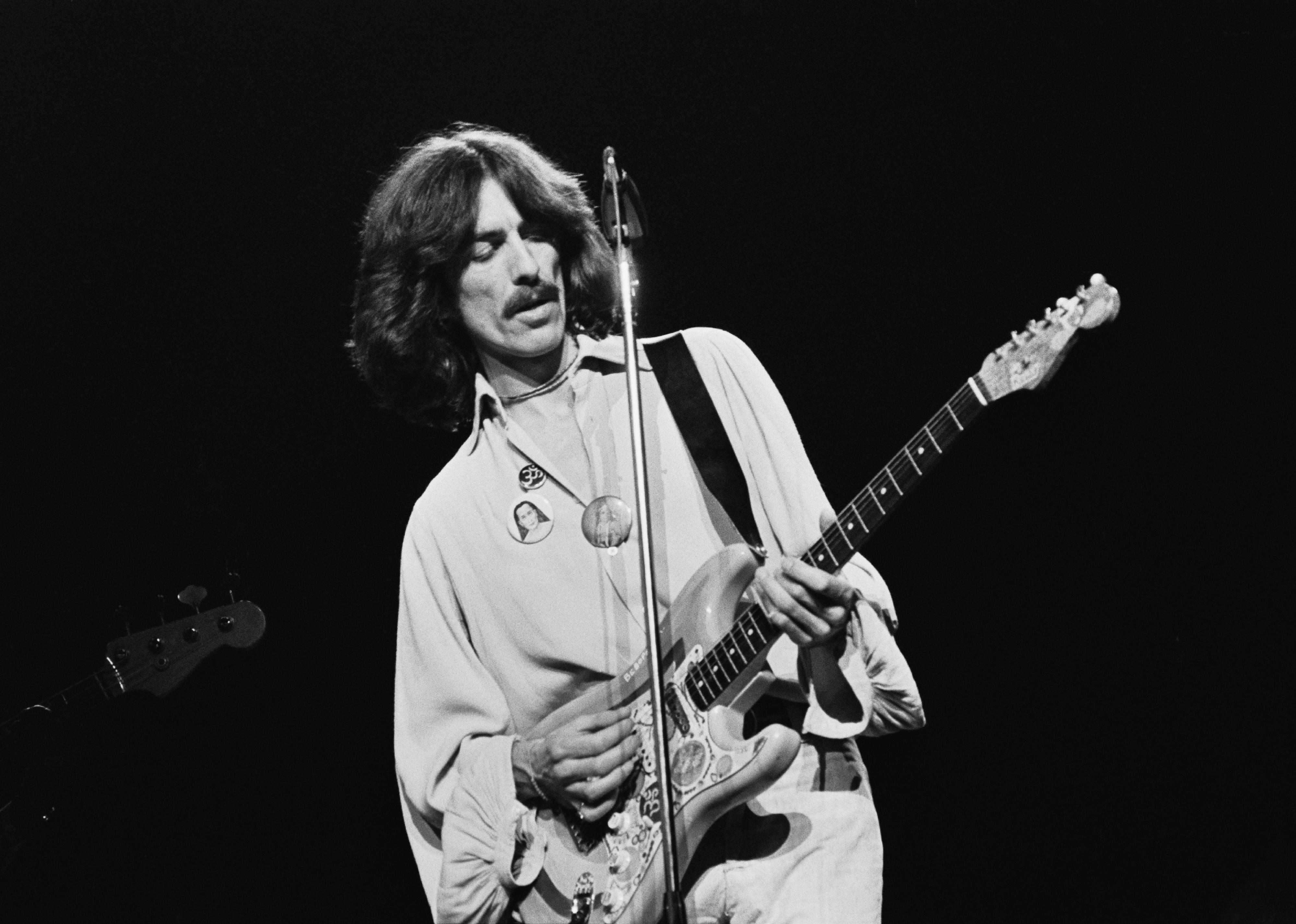 George Harrison performing on stage playing his 'Rocky' Sonic Blue Fender Stratocaster. 
