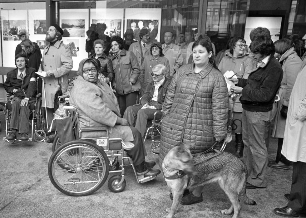 Handicapped citizens gather at the entrance to the John F. Kennedy Federal Building 