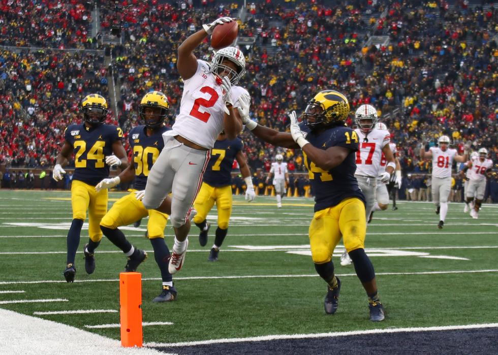 J.K. Dobbins #2 of the Ohio State Buckeyes dives for a fourth quarter touchdown past Josh Metellus #14 of the Michigan Wolverines