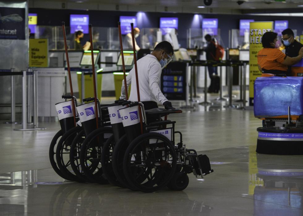 A United Airlines employee transfers wheelchairs