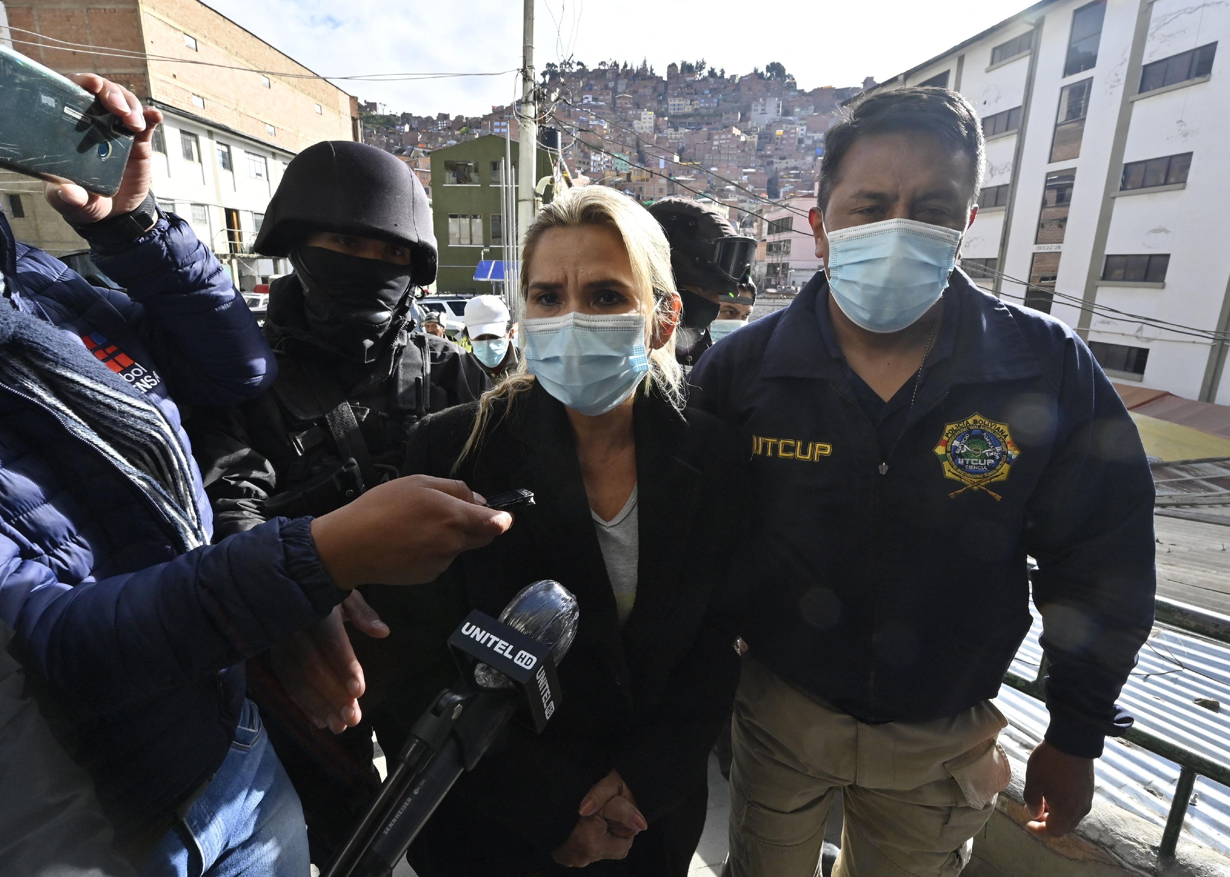 Jeanine Anez escorted by police members of the Special Force against Crime