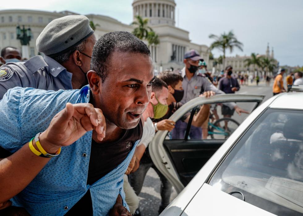 A man is arrested during a demonstration against the Cuban President