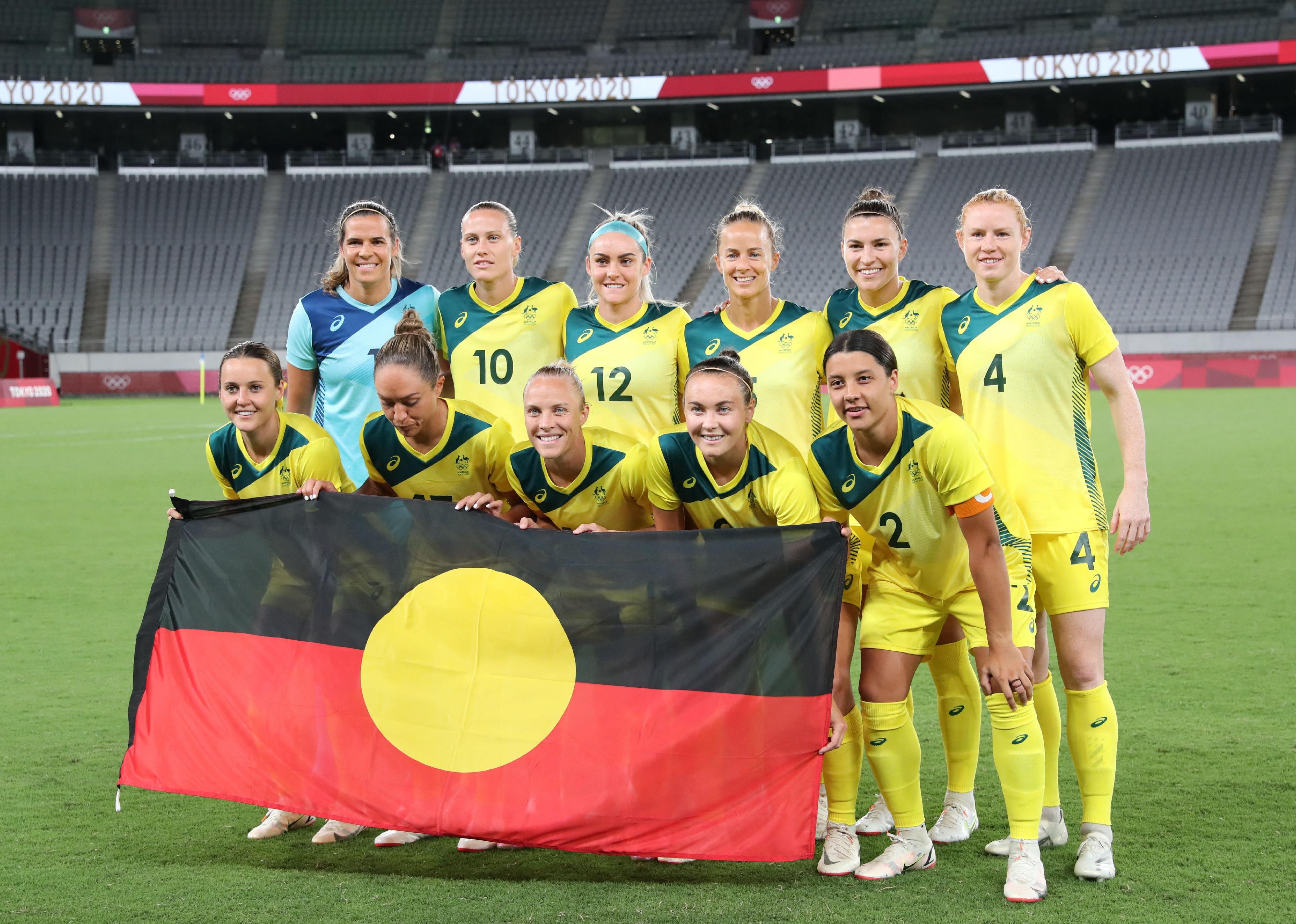 Australia poses for a team photo with the Australian Aboriginal flag prior to the Tokyo 2020 Olympic Games women's group G first round football match.