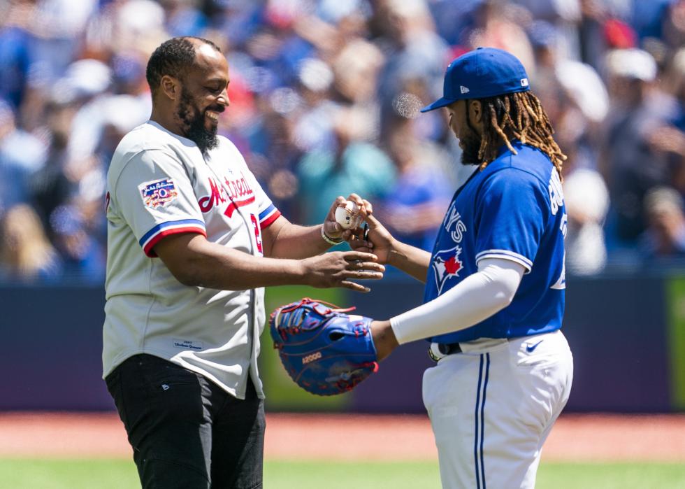 Vladimir Guerrero Jr. of the Toronto Blue Jays gives a ball to his father, Vladimir Guerrero Sr.