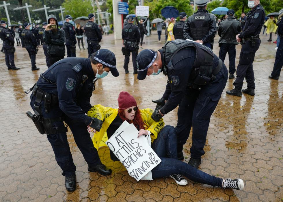 Police officers attempt to remove a female protestor
