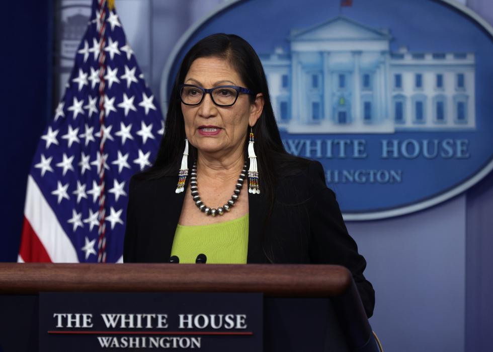 Deb Haaland speaks into a mic behind a White House podium.