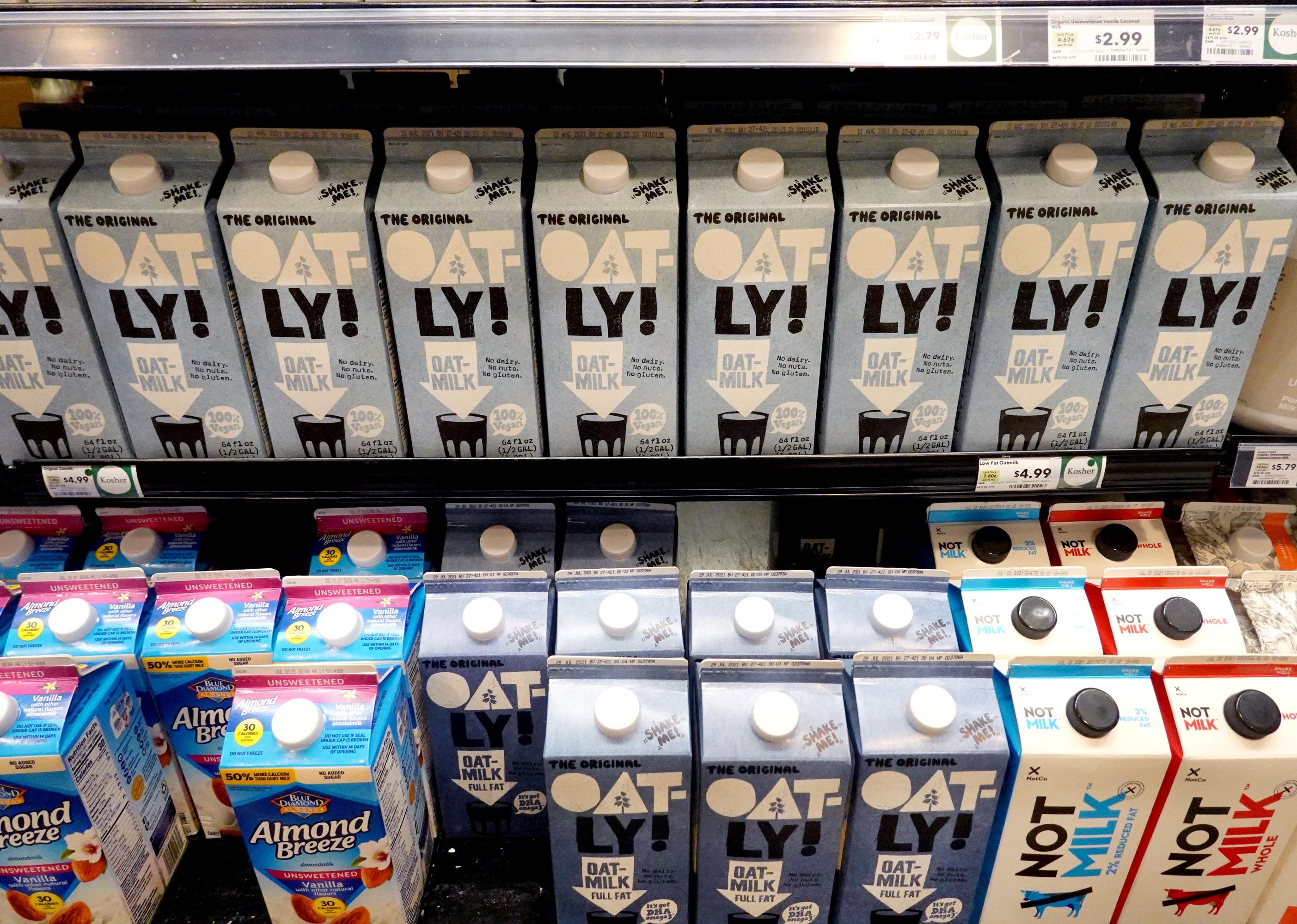 Containers of oat milk on display in store.