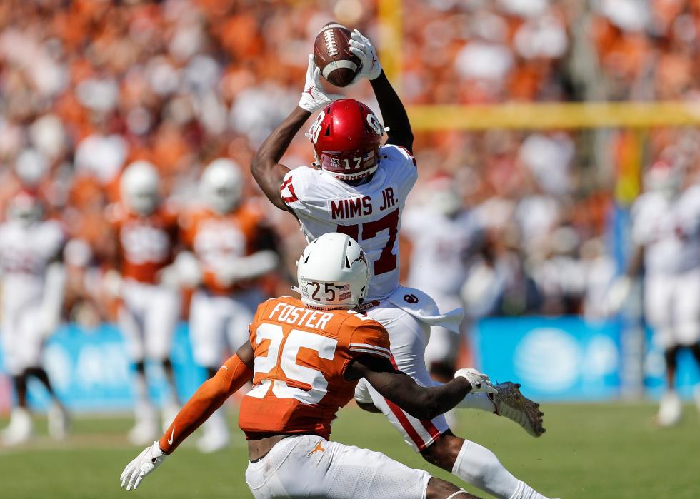 Marvin Mims of the Oklahoma Sooners catches a pass while defended by B.J. Foster of the Texas Longhorns