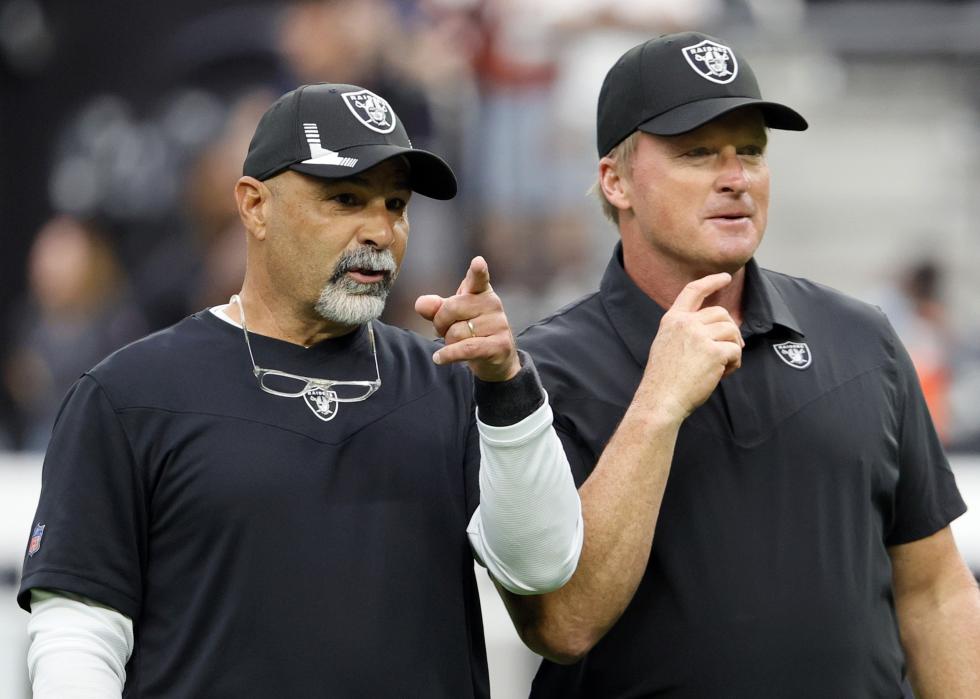 Assistant head coach Rich Bisaccia and head coach Jon Gruden of the Las Vegas Raiders talk on the field