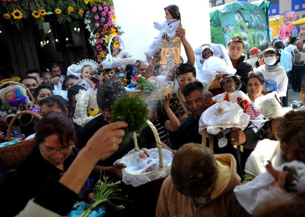 A packed crowd of people holding dolls and baskets of different sizes.