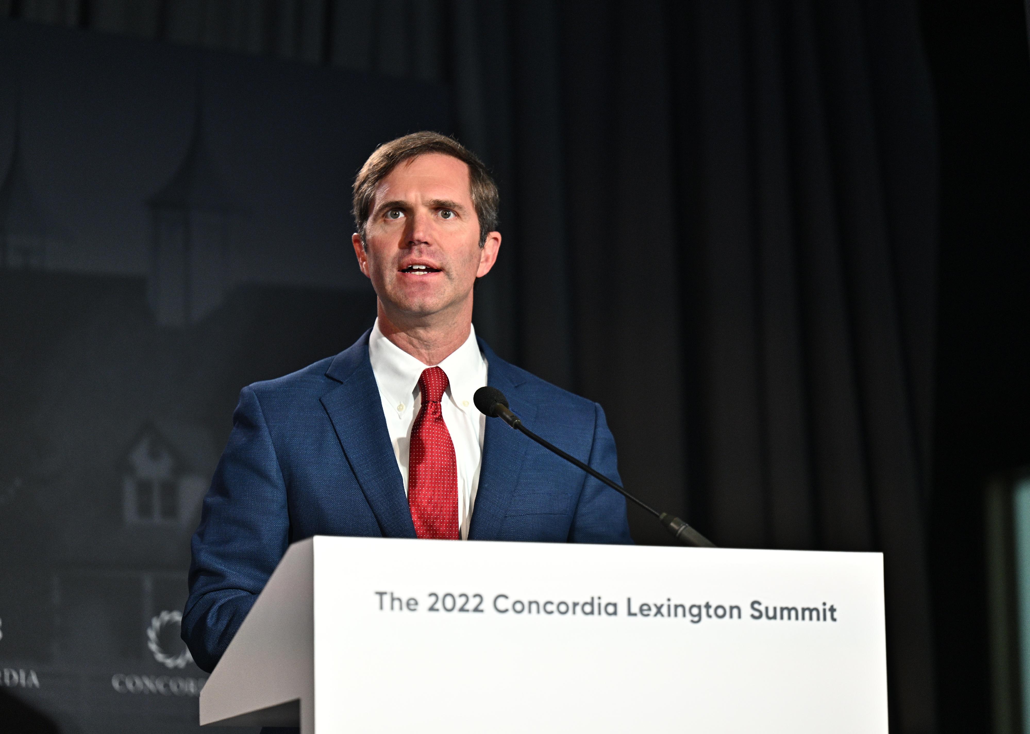 Andy Beshear speaks onstage at a summit in Lexington