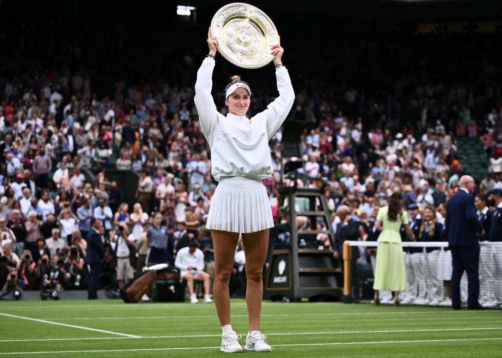 Marketa Vondrousova celebrates with the Venus Rosewater Dish trophy.