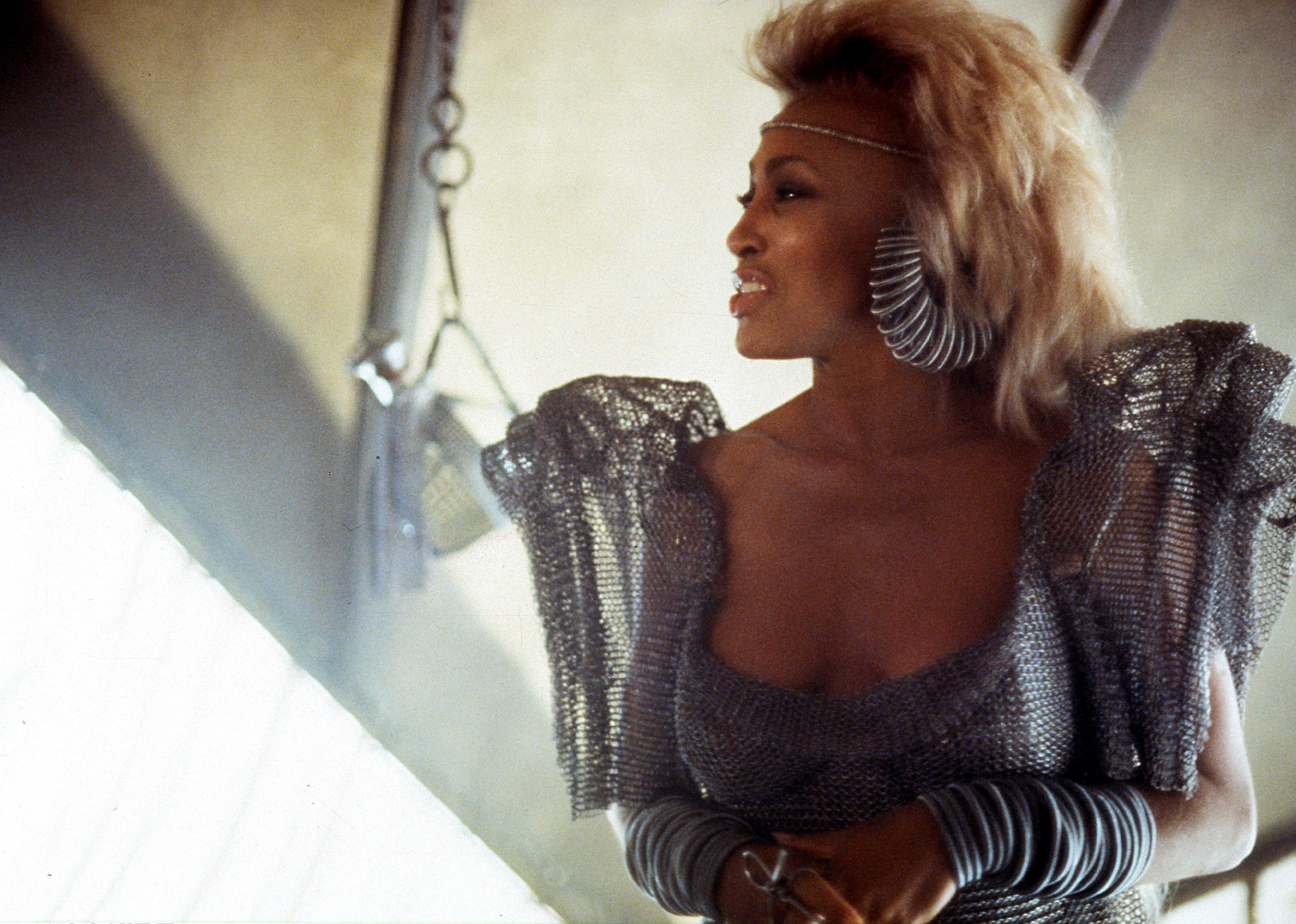 Tina Turner wearing silver attire in a scene from the film 'Mad Max: Beyond Thunderdome', 1985.