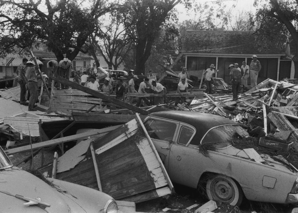 People sorting through wreckage on a residential street.