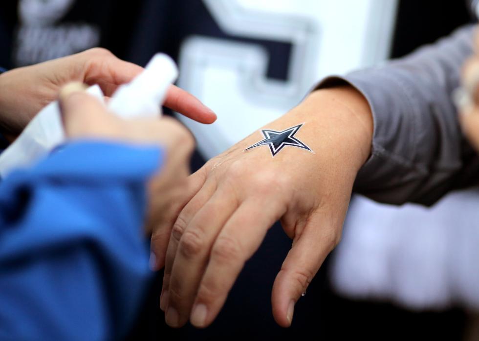 A Cowboys fan dons a Cowboys star temporary tattoo at Wembley Stadium.