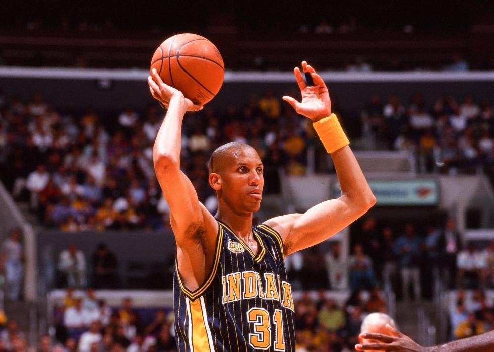 Reggie Miller of the Indiana Pacers holding a ball high during a game