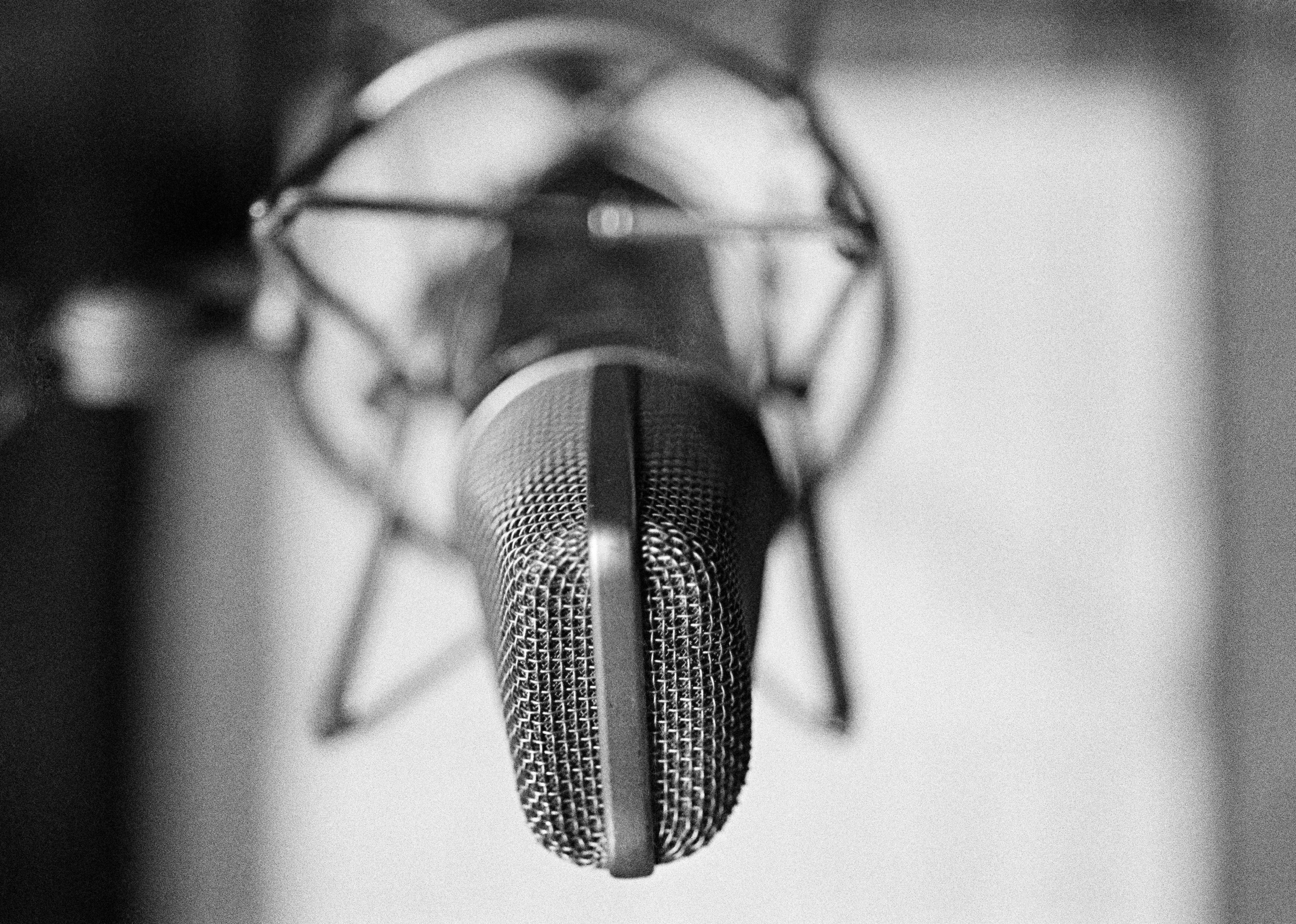 General view of a condenser microphone in a shock mount in a recording studio.