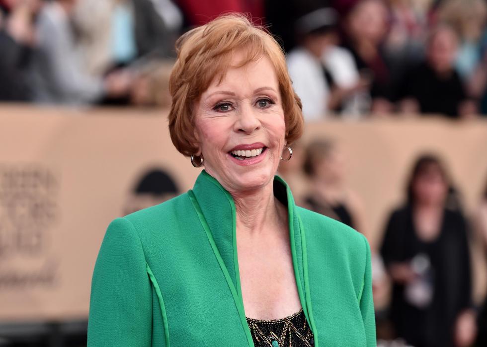 Carol Burnett smiling with a crowd behind her. 