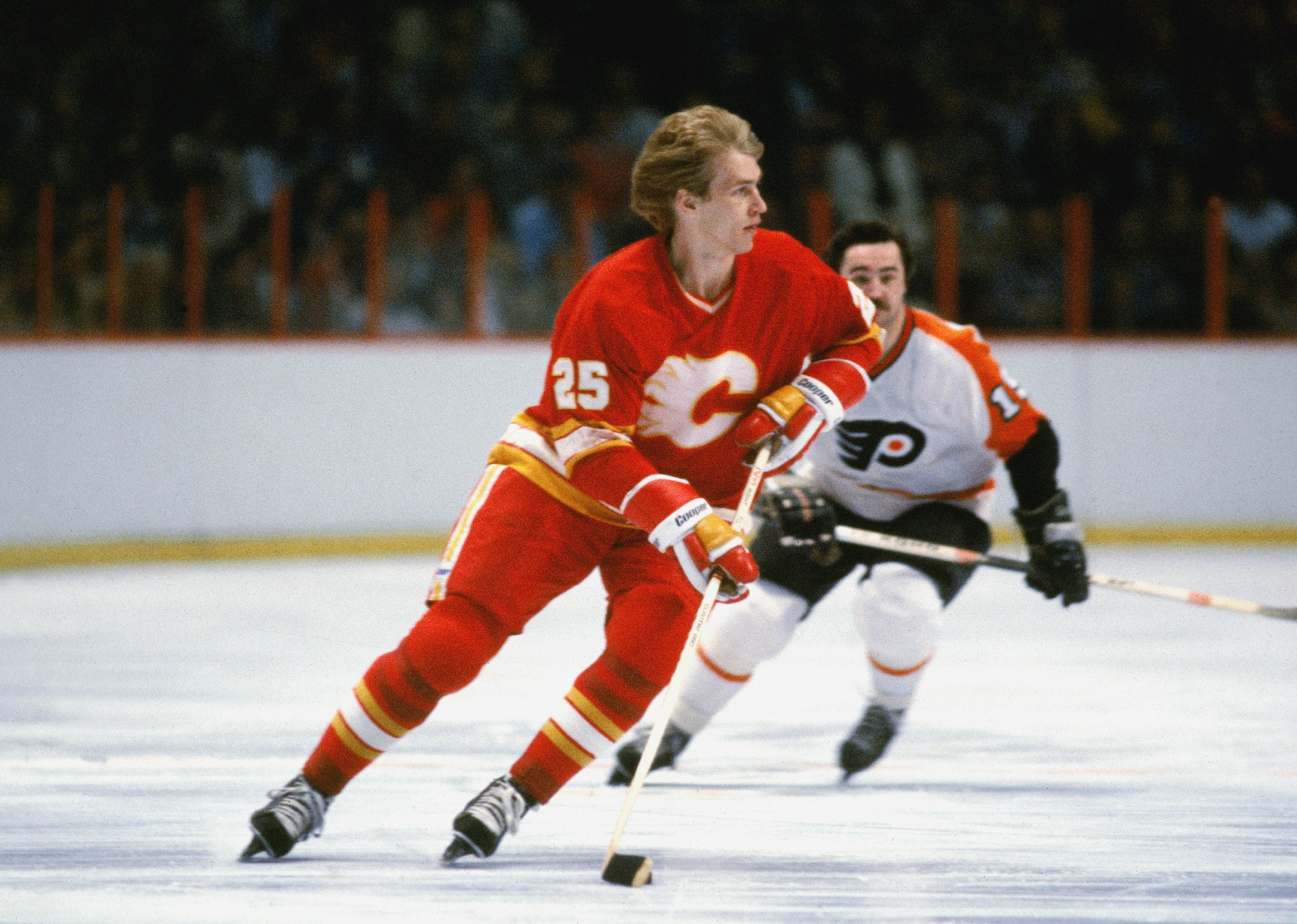 Willi Plett skates without a helmet on the ice in a game.