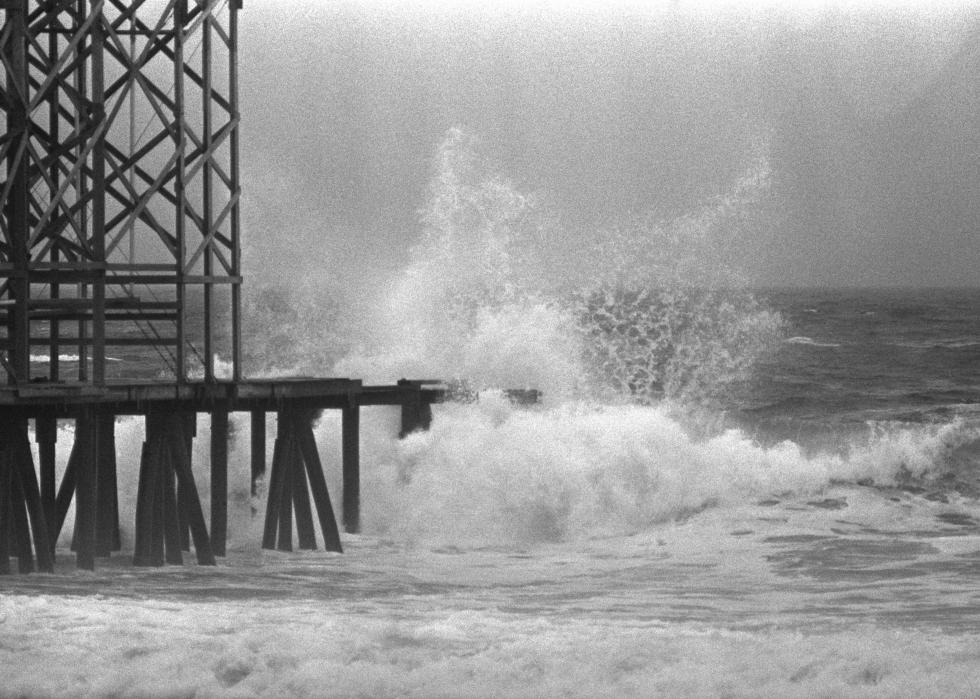 Waves crash against a boardwalk.