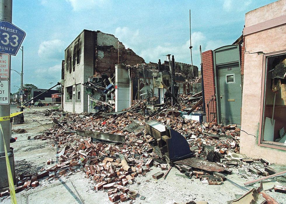 A small town street with destroyed buildings and debris after a storm.