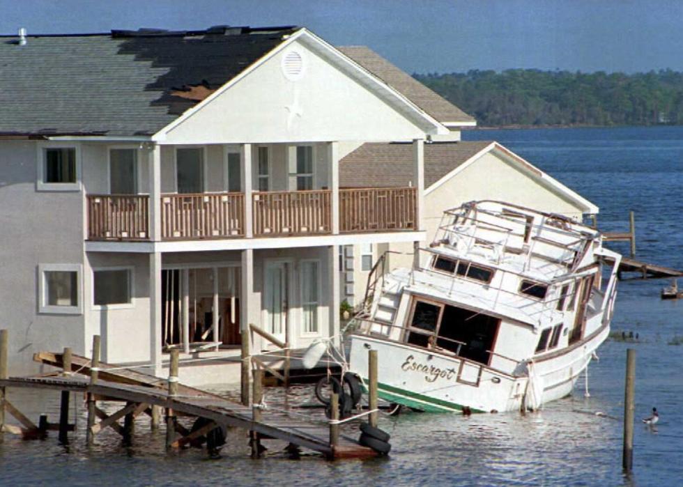 A boat crashed into the front porch of a home surrounded by water.