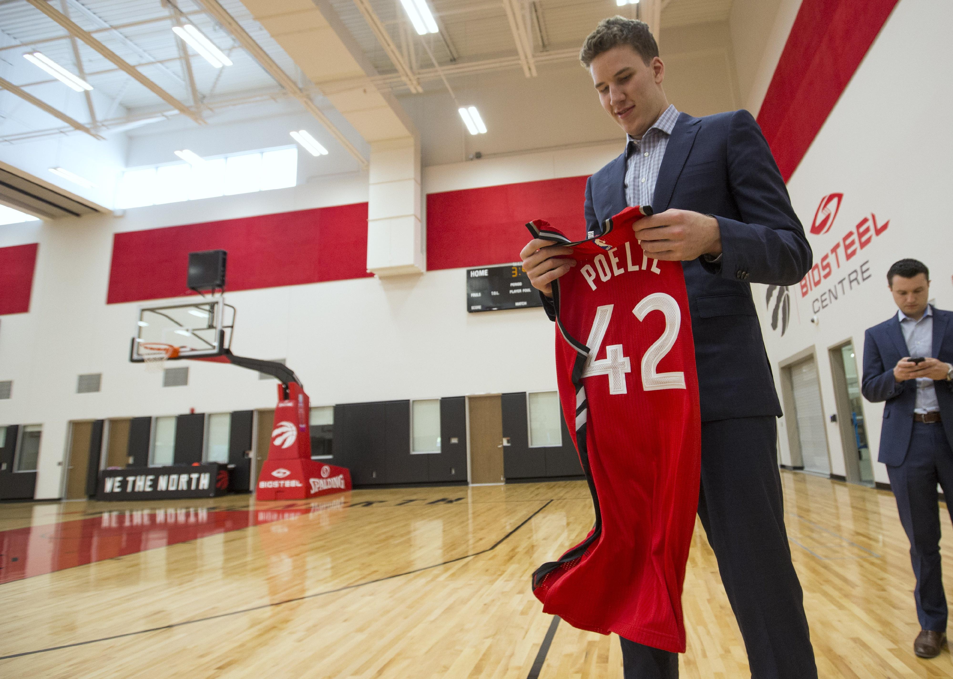 Jakob Poeltl looking at his jersey in a gym at BioSteel Centre.