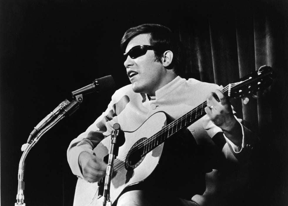 José Feliciano plays the guitar and sings onstage.